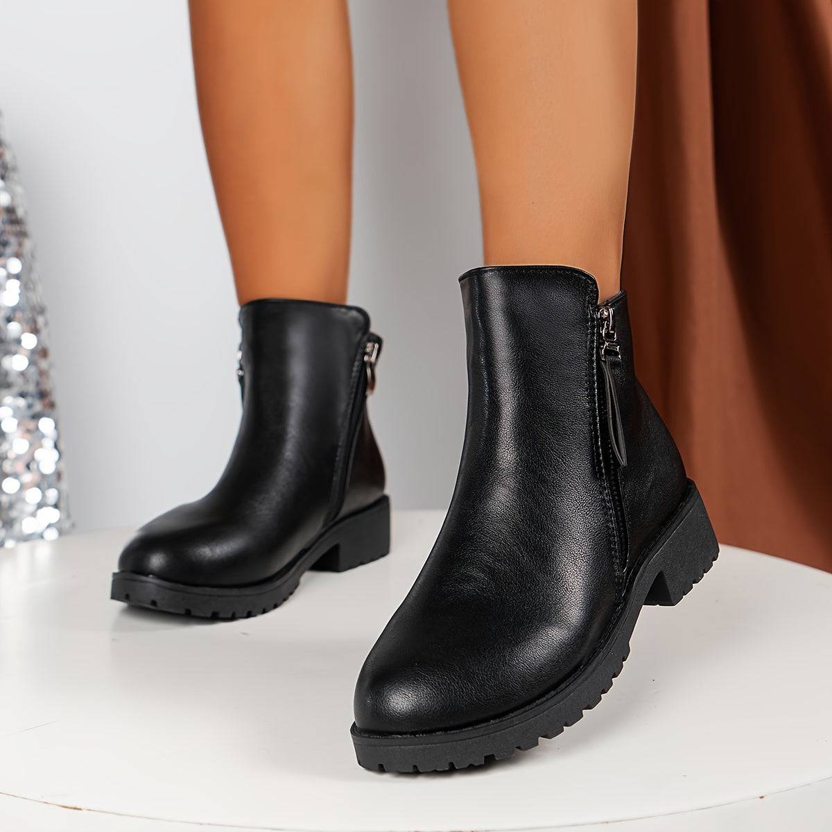 Schwarze Damenstiefeletten mit Doppelreißverschluss und niedrigem Absatz.